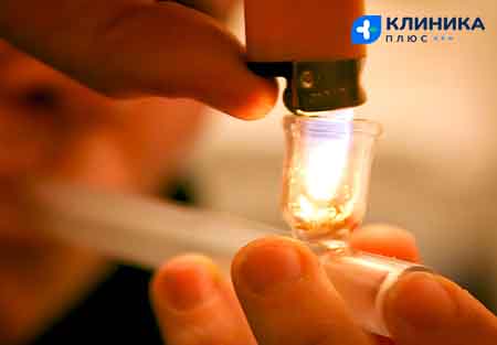 Наркоман курит крэк из стеклянной трубки